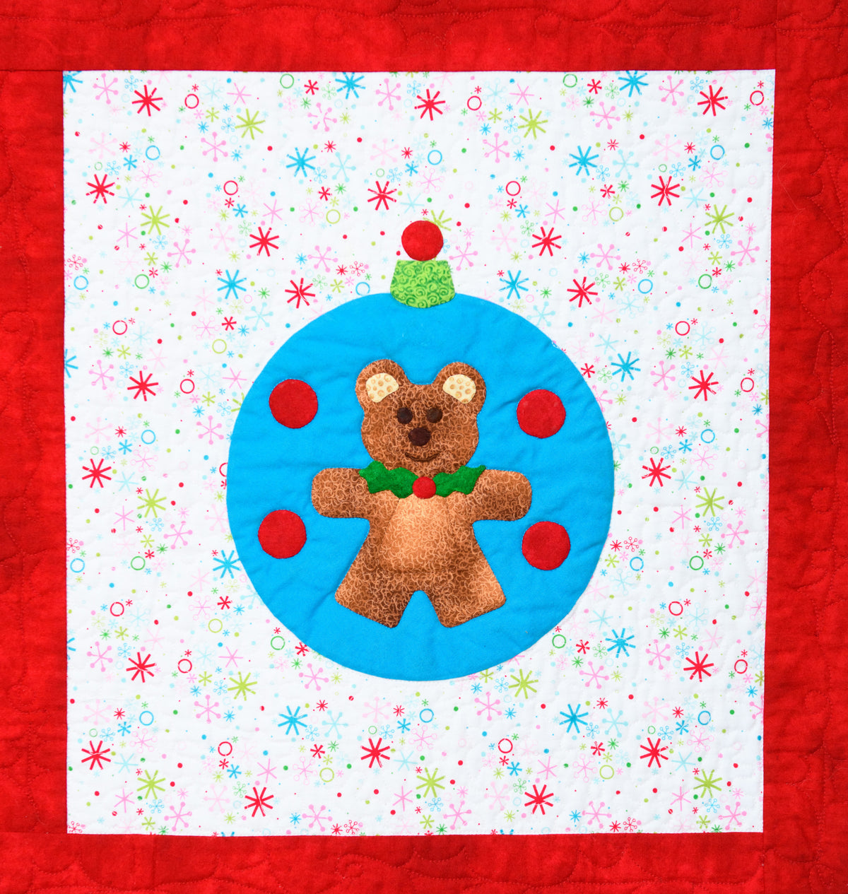 Bear Ornament appliqué quilt pattern on a blue ornament and Christmas background fabric