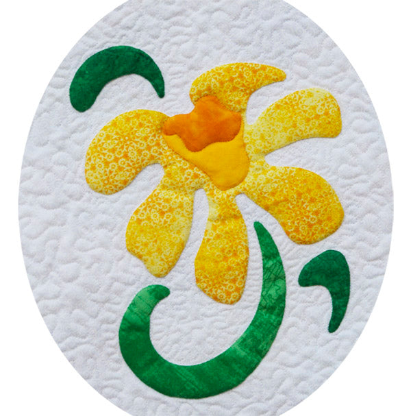 Yellow daffodil with an orange center and green leaves on a white background fabric appliqué quilt pattern