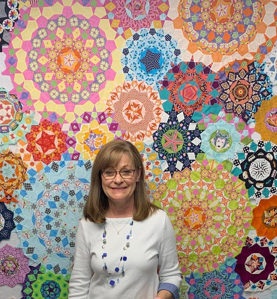 Me in front of a colorful quilt