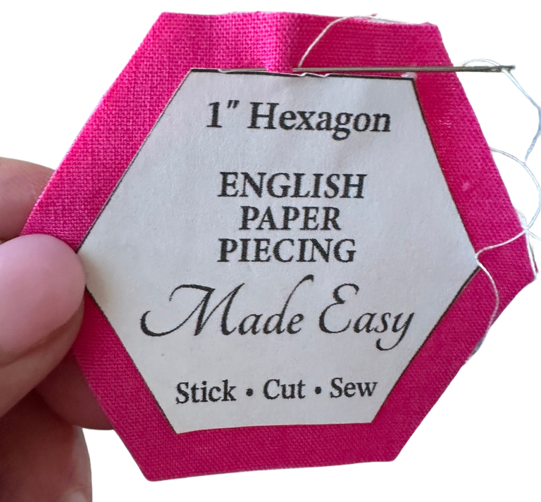 Hexagonal English Paper Piecing tool with pink border and label on a white background straight stitching by hand